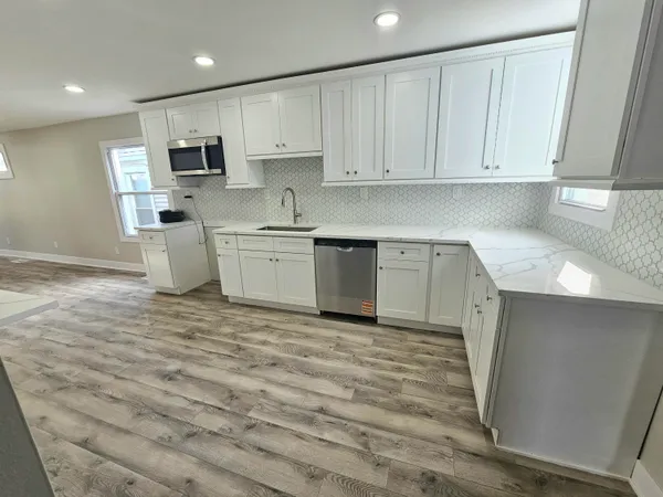 a kitchen with stainless steel appliances granite countertop a stove a sink and a microwave