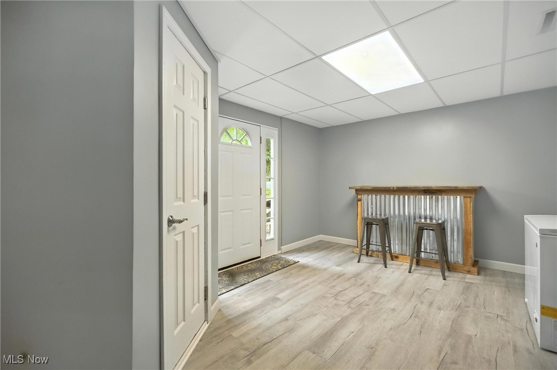 1371 Spider Ridge Road Parkersburg, WV 26104 - Photo 32 of 48 Foyer entrance featuring light wood-type flooring, a paneled ceiling, and a bar