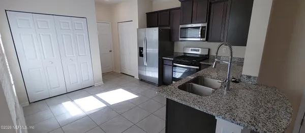 a kitchen with stainless steel appliances granite countertop a refrigerator and a sink