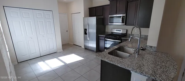 a kitchen with stainless steel appliances granite countertop a refrigerator and a sink
