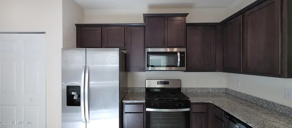 a kitchen with granite countertop wooden cabinets and stainless steel appliances