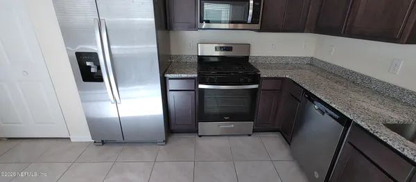 a kitchen with granite countertop a refrigerator and a stove