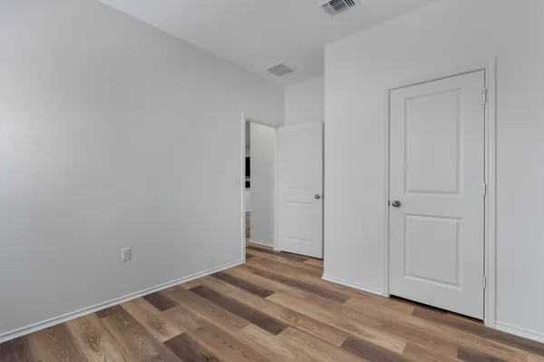 a view of a room with wooden floor and a window