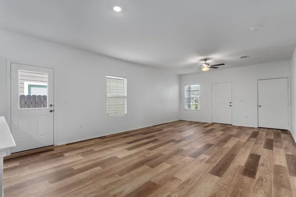 a view of empty room with window and ceiling fan
