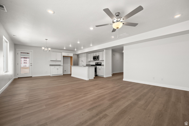 1554 Pheasant Road Eagle Mountain, UT 84005 - Photo 4 of 29 Unfurnished living room with suspended lighting, ceiling fan, and dark wood-style floors