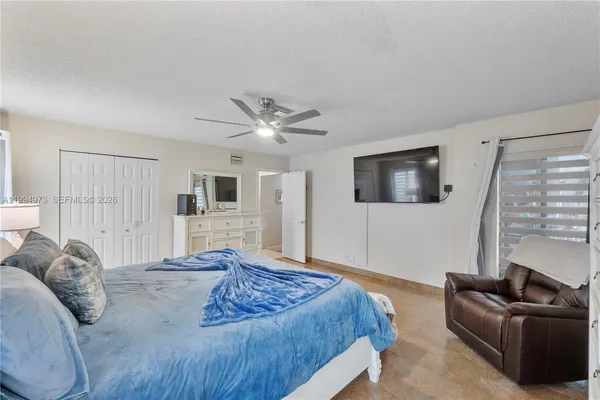 a spacious bedroom with a bed and a flat screen tv