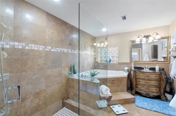 a bathroom with a granite countertop sink a mirror and shower