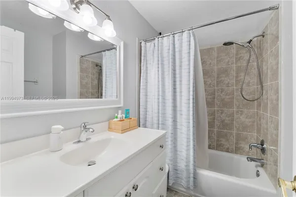 a bathroom with a sink vanity tub and shower