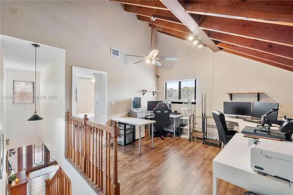 a view of a workspace with furniture and wooden floor