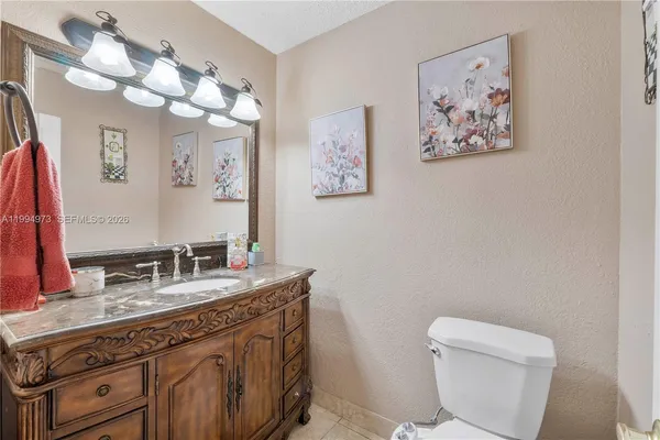 a bathroom with a granite countertop sink mirror and toilet