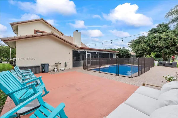 a view of backyard with swimming pool and seating space