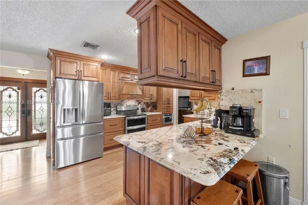 a kitchen with stainless steel appliances granite countertop a refrigerator and stove