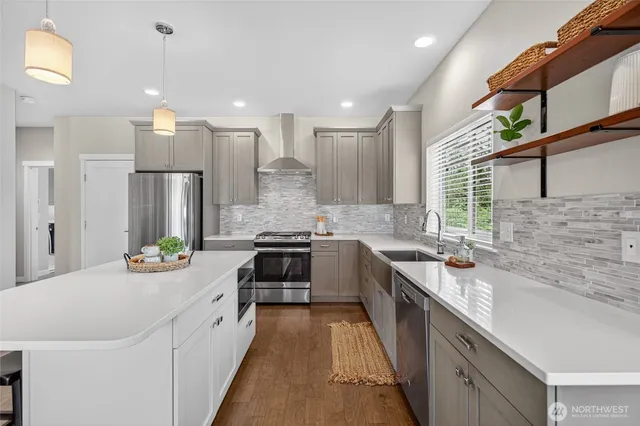 a large kitchen with stainless steel appliances lots of counter space and wooden floor