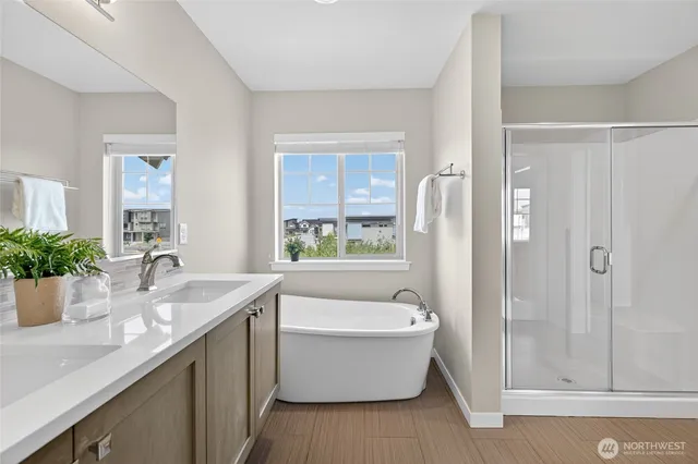 a bathroom with a granite countertop tub sink and mirror