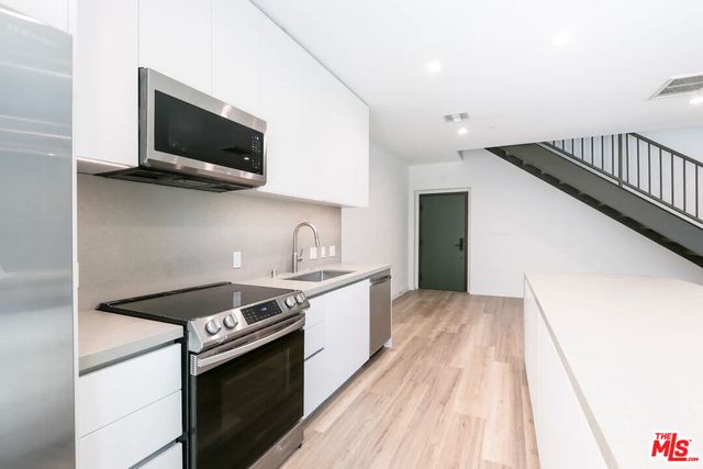 a kitchen with stainless steel appliances granite countertop a sink and a stove