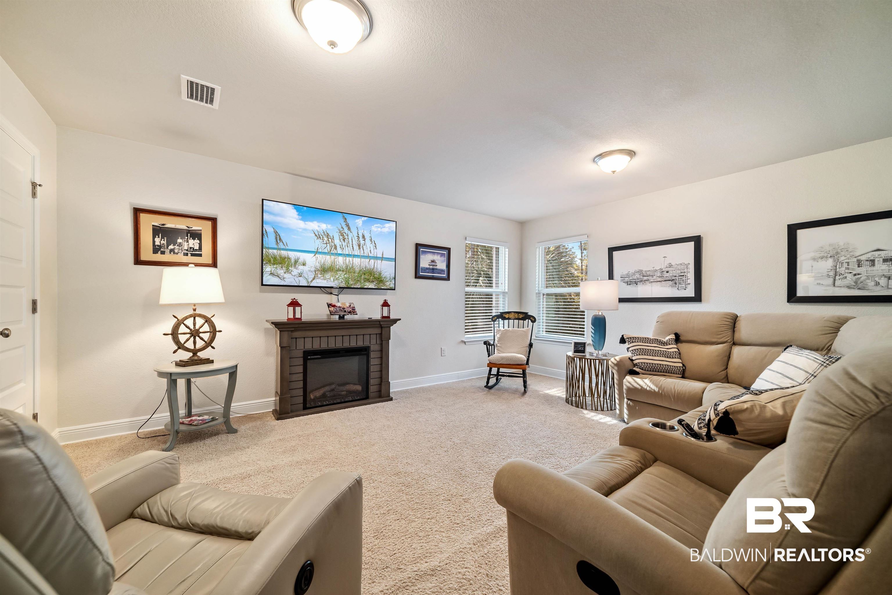 1290 Mako Loop Gulf Shores, AL 36542 - Photo 21 of 50 Carpeted living room featuring a brick fireplace, baseboards, and visible vents