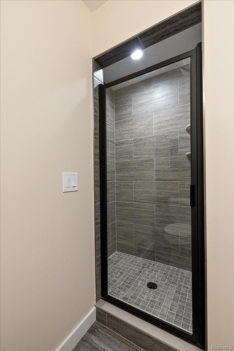 2032 Breckenridge Court, Unit 9 Rochester, MI 48309 - Photo 37 of 39 Bathroom featuring a shower stall and dark wood-style flooring