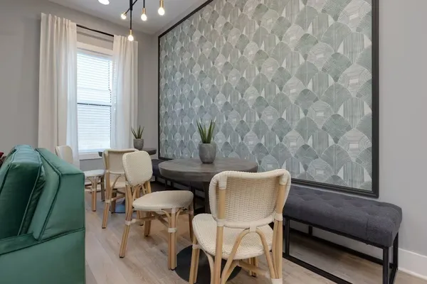 a kitchen with stainless steel appliances a dining table chairs and a refrigerator