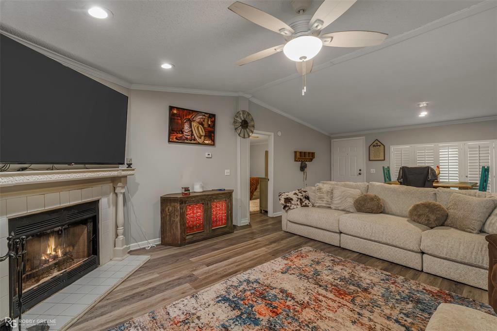 8273 Godfrey Road Shreveport, LA 71129 - Photo 5 of 27 Fireplace with a tile hearth and mantle, wood-finish flooring, recessed lighting, and a ceiling fan
