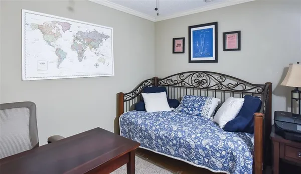 a bedroom with a bed and painting on the wall