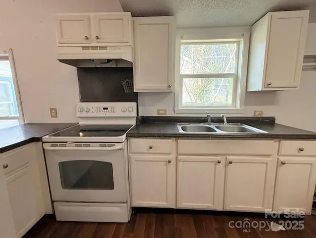 a kitchen with stainless steel appliances granite countertop a sink and a stove