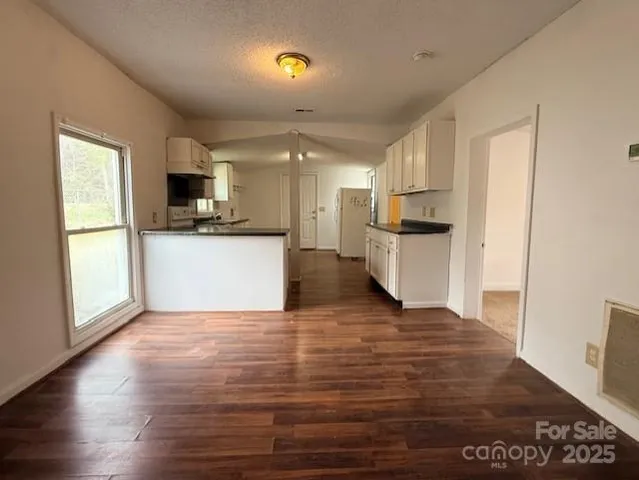 a view of a kitchen with a sink stove cabinets and empty room