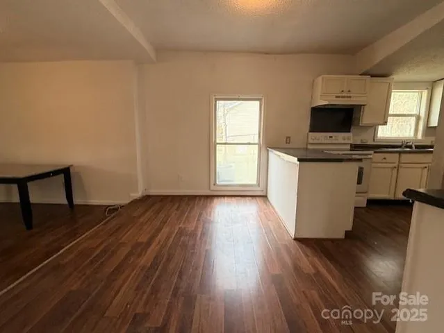 a view of a kitchen with wooden floor and a sink