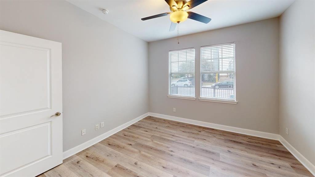 4904 Live Oak Street, Unit 1 Dallas, TX 75206 - Photo 13 of 20 an empty room with wooden floor fan and windows