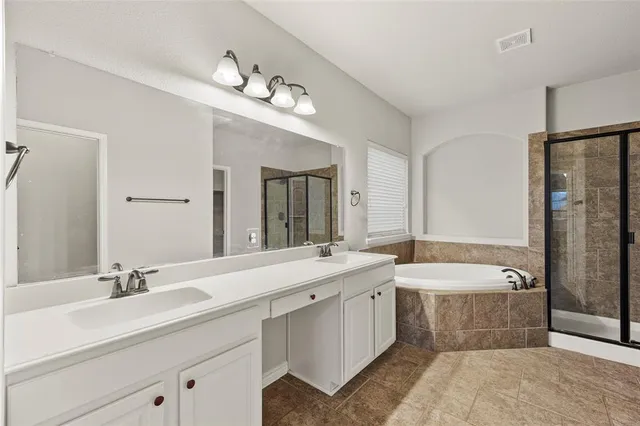 a bathroom with a double vanity sink large mirror and a bathtub