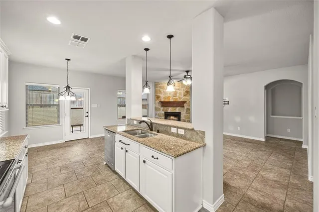 a kitchen with kitchen island a counter top space appliances and a sink