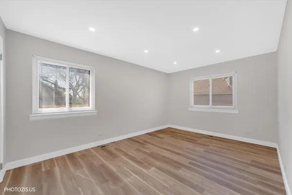 a view of empty room with window and wooden floor