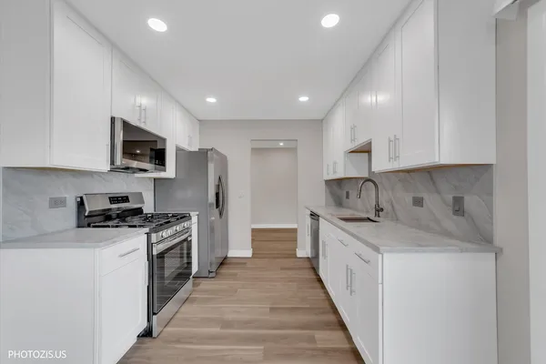 a kitchen with stainless steel appliances granite countertop a sink stove and refrigerator