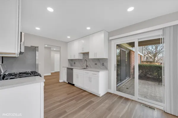 a kitchen with a sink a refrigerator and white cabinets