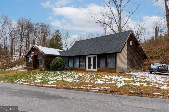 a front view of a house with a yard covered with snow