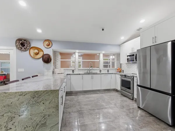 a large kitchen with a refrigerator and a stove