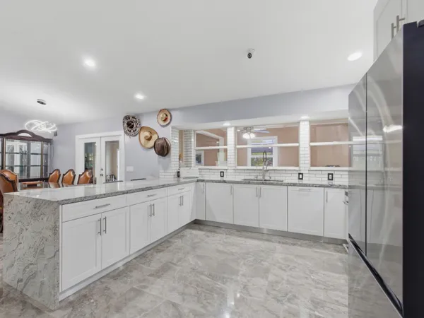 a large white kitchen with sink and cabinets