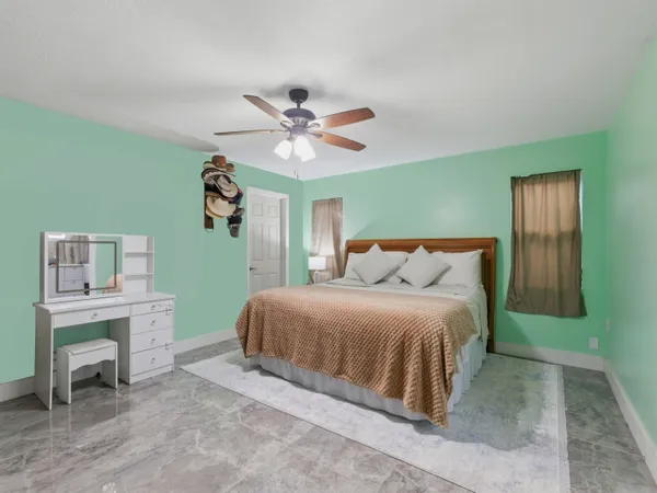 a spacious bedroom with a bed and a chandelier