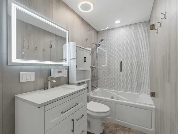 a bathroom with a granite countertop sink toilet and shower
