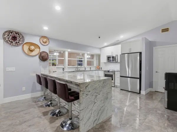a kitchen with stainless steel appliances granite countertop a sink and a refrigerator