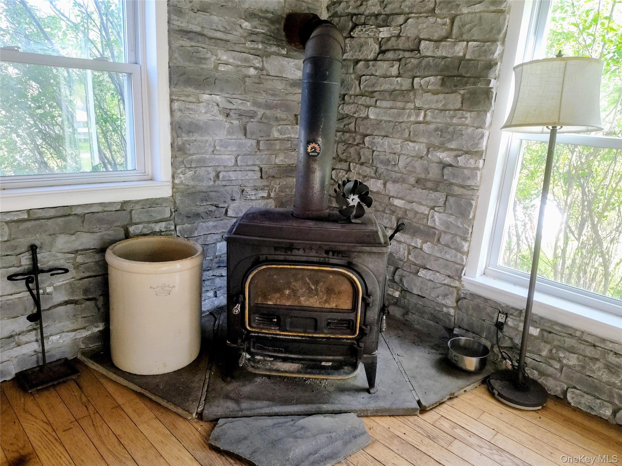983 Plank Road Forestburgh, NY 12777 - Photo 17 of 50 Corner wood stove with a stone surround and wood-finish flooring