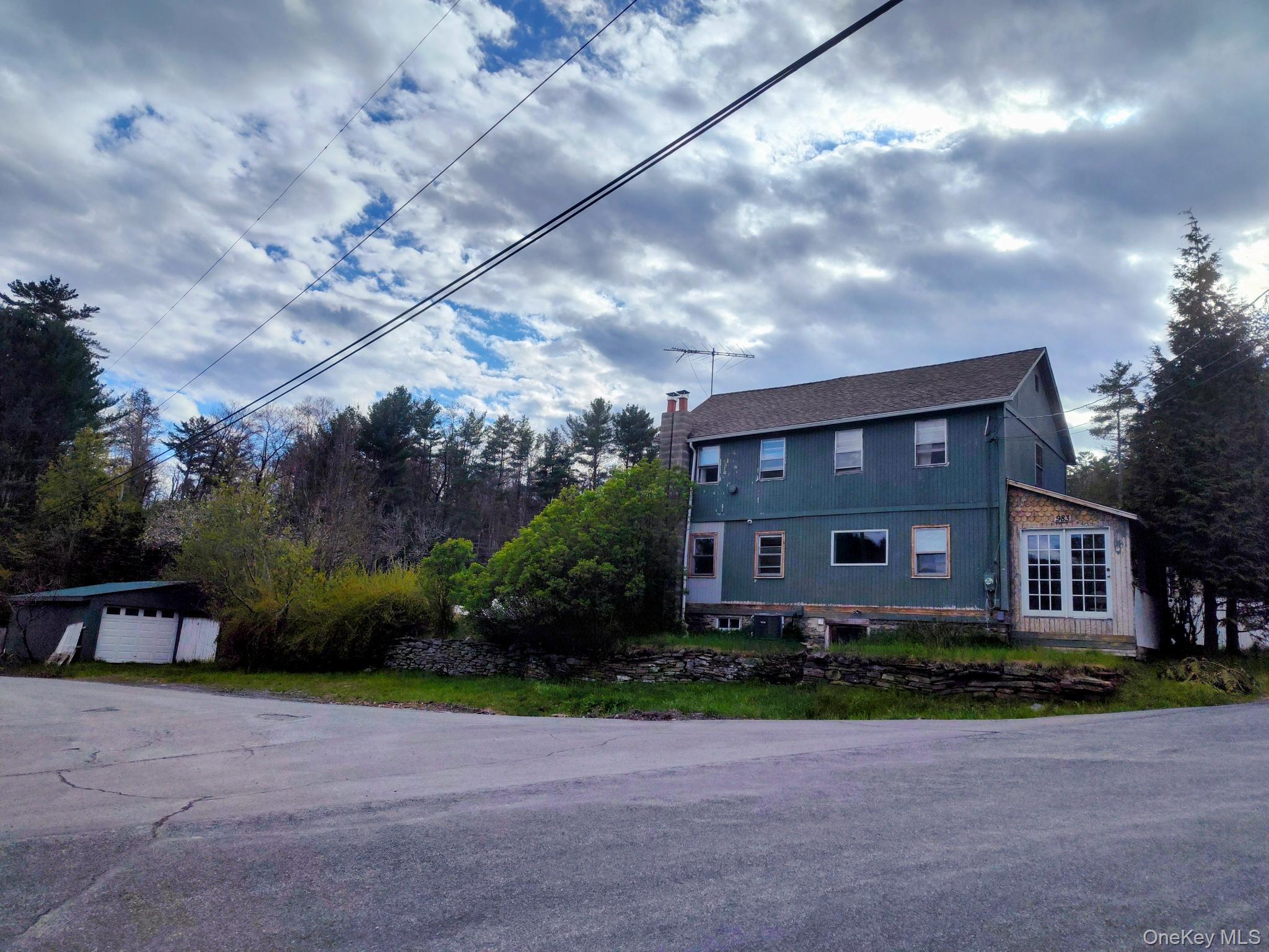 983 Plank Road Forestburgh, NY 12777 - Photo 41 of 50 Two-story residence with a pitched roof, featuring a chimney and an attached sunroom with multiple windows for warmth and sunlight....