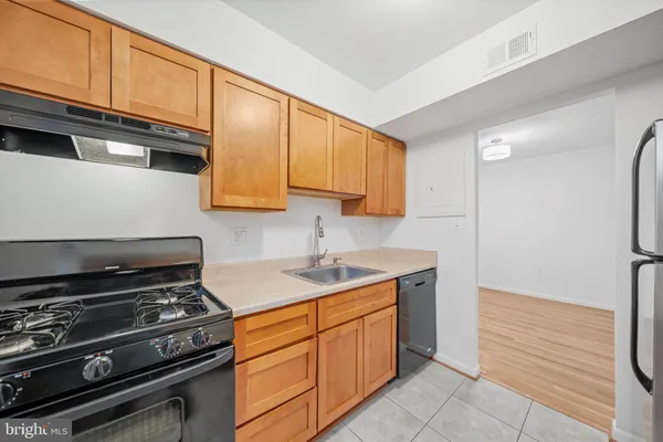 a kitchen with stainless steel appliances a stove a sink and cabinets