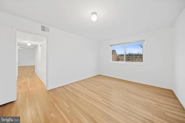 a view of an empty room with wooden floor