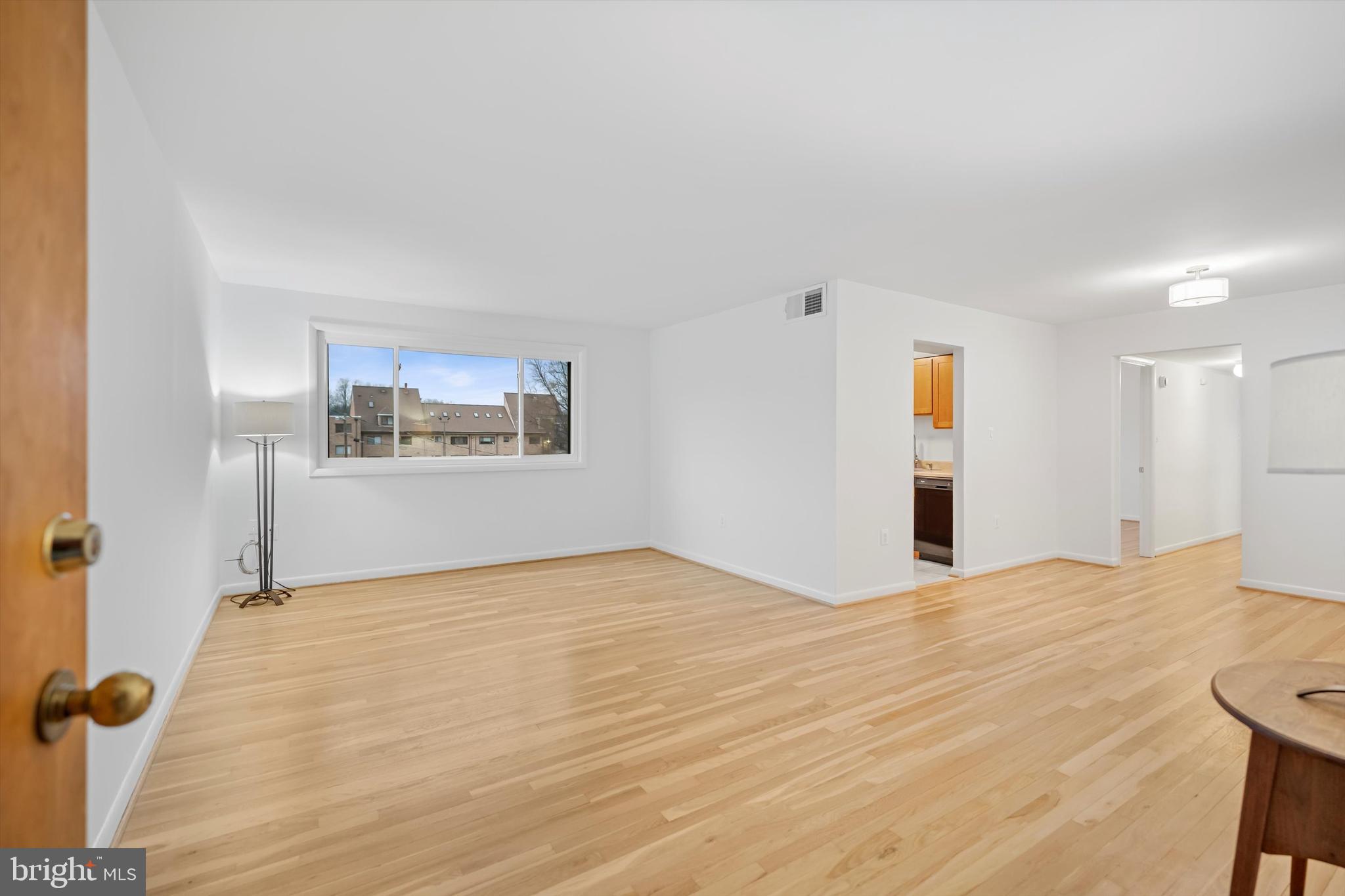 11508 Bucknell Drive, Unit 203 Silver Spring, MD 20902 - Photo 5 of 21 a view of an empty room with a window and wooden floor