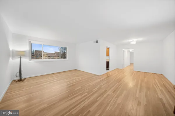 a view of a room with wooden floor and white walls