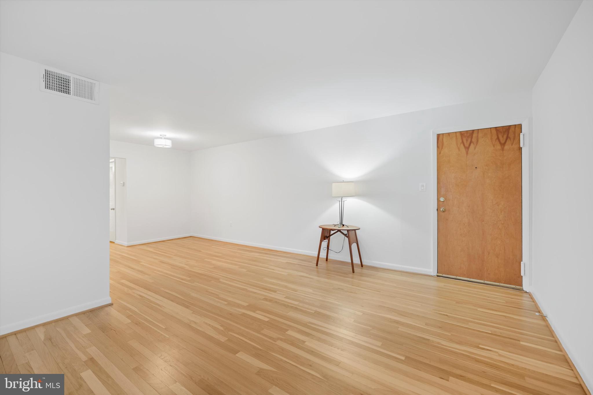 11508 Bucknell Drive, Unit 203 Silver Spring, MD 20902 - Photo 8 of 21 a view of a room with wooden floor table and a painting