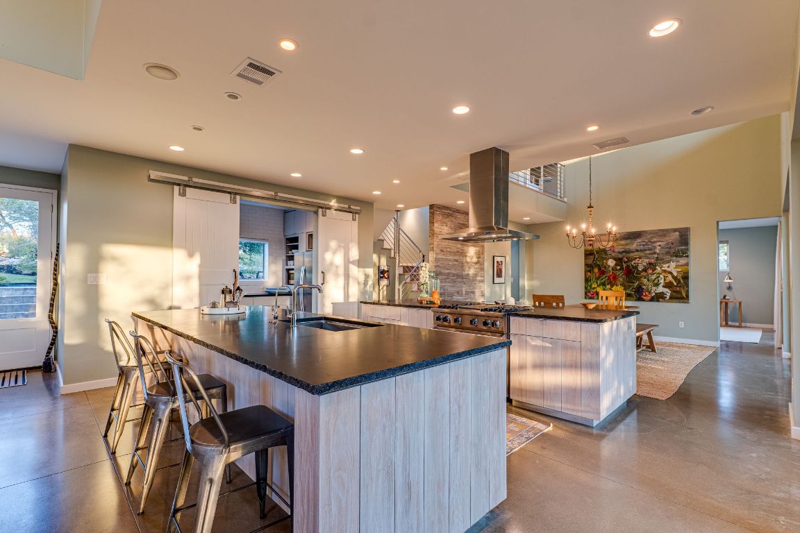 23601 Old Ferry Road, Unit 20 Spicewood, TX 78669 - Photo 40 of 40 a kitchen with stainless steel appliances granite countertop a table chairs and a refrigerator