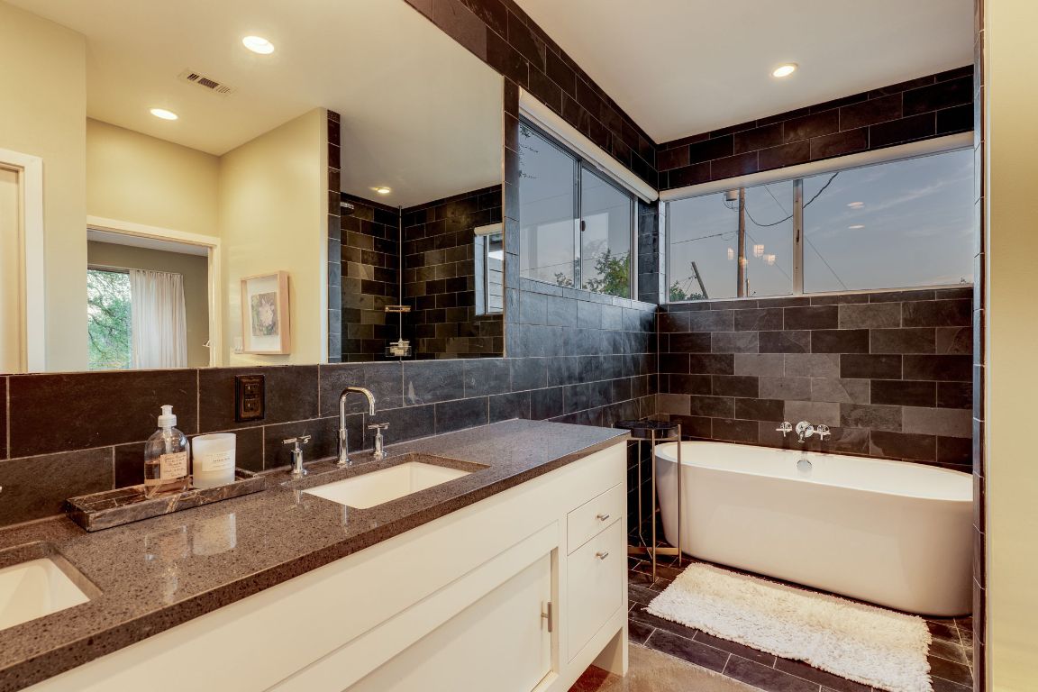 23601 Old Ferry Road, Unit 20 Spicewood, TX 78669 - Photo 23 of 40 a bathroom with a double vanity sink a mirror and shower