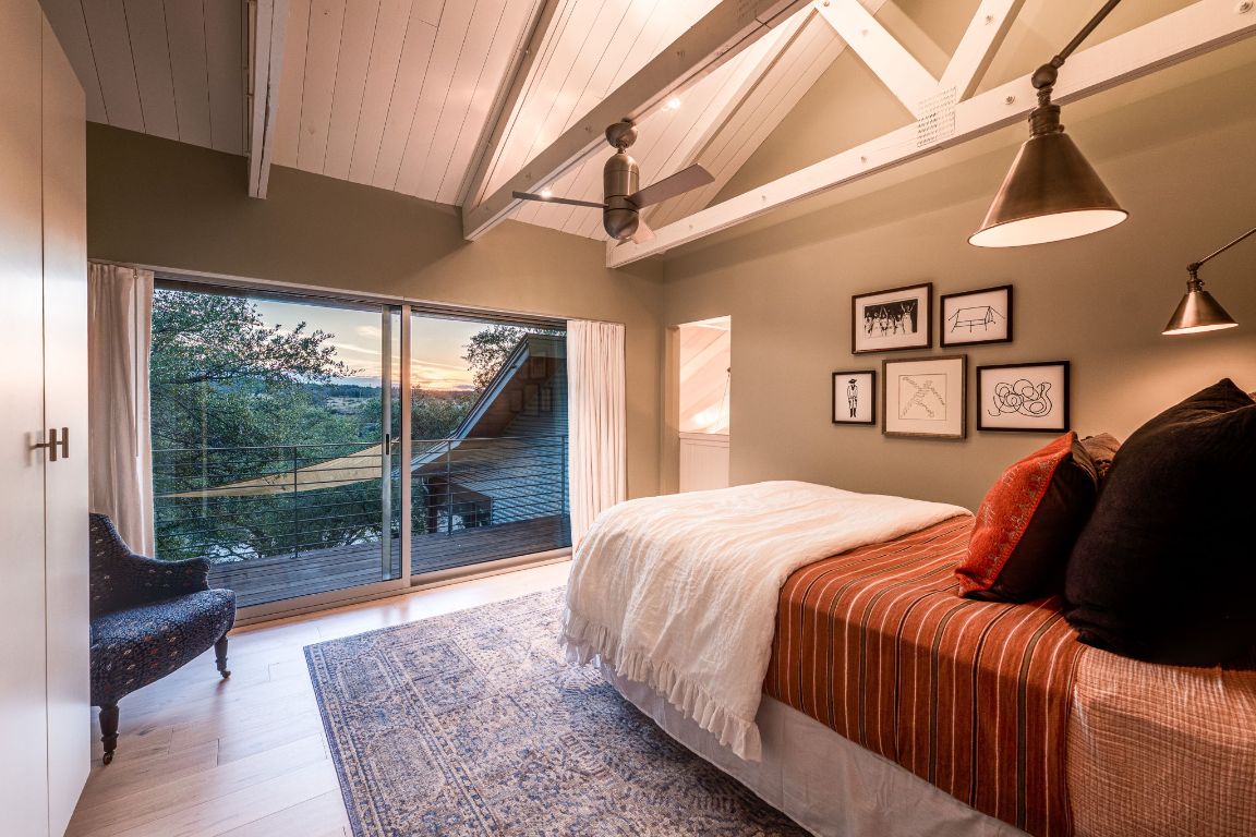 23601 Old Ferry Road, Unit 20 Spicewood, TX 78669 - Photo 27 of 40 a bedroom with a large bed and a large window