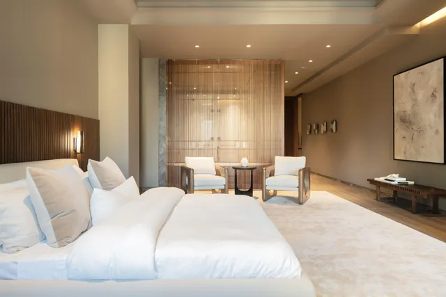 a large bedroom with a bed and glass windows